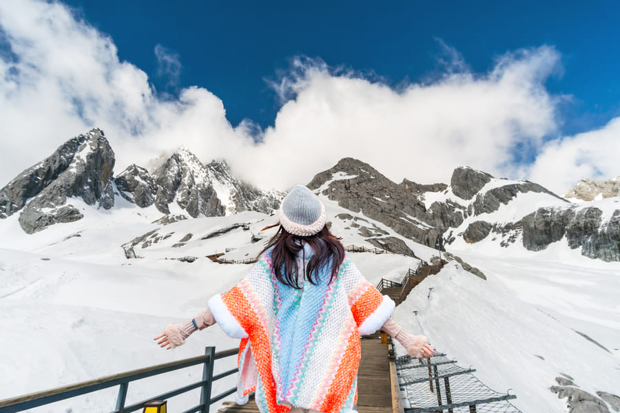 Mujer de espaldas frente a Montaña Nevada del Dragón de Jade (Yulong Shan)
