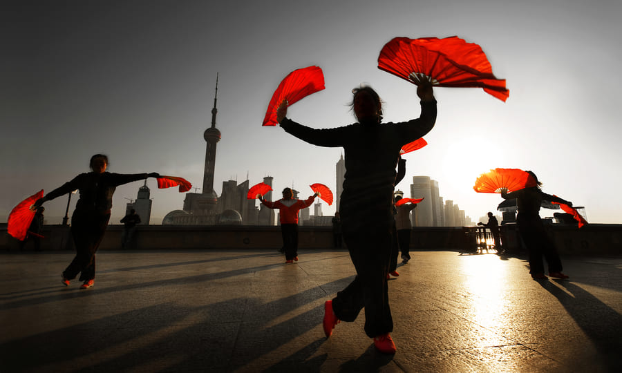 Gente bailando con abanicos rojos en China